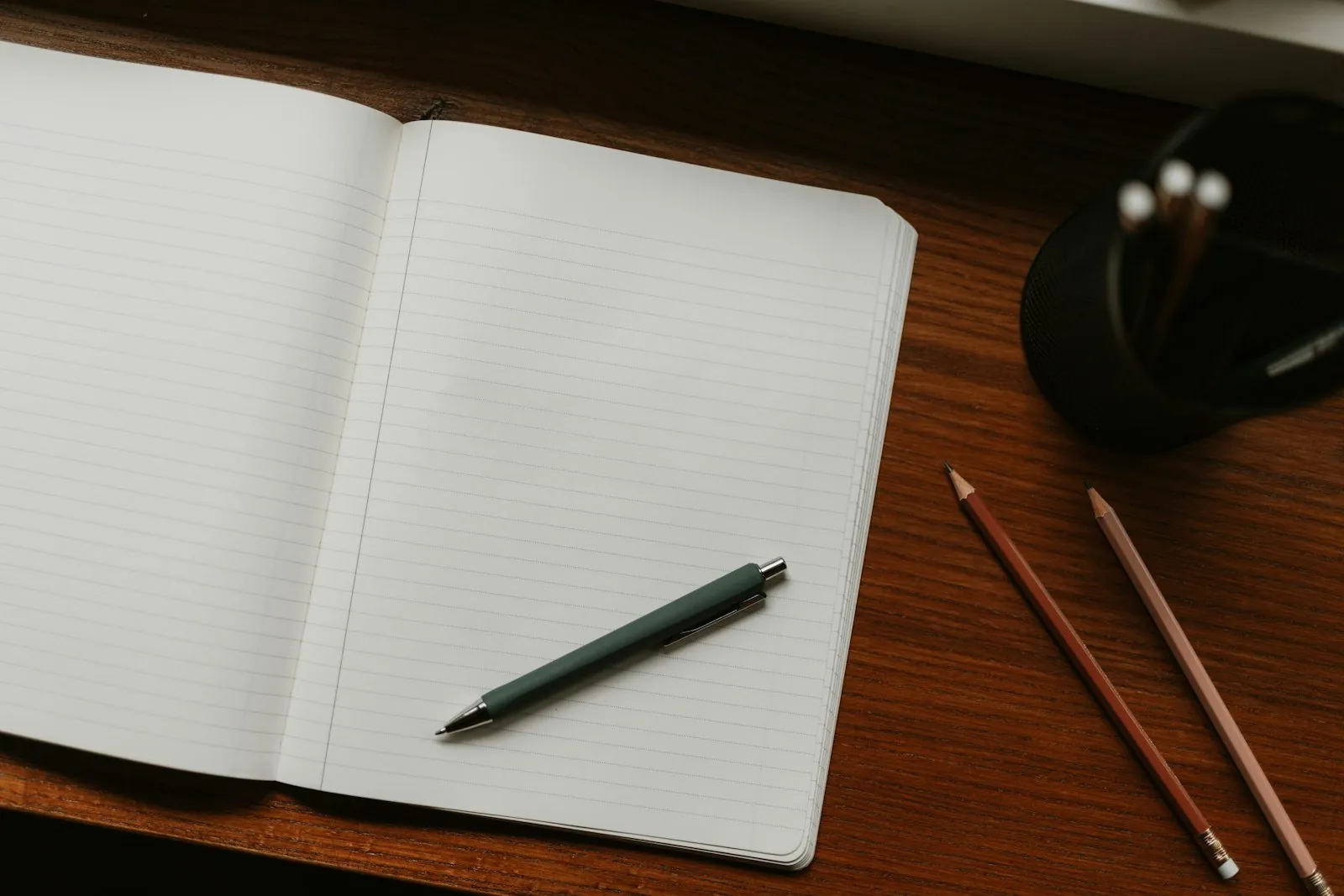 Carnet ouvert et crayons sur un bureau en bois